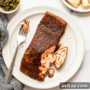 A succulent smoked salmon fillet on a plate with a fork, showing its flaky texture and readiness to be savored.