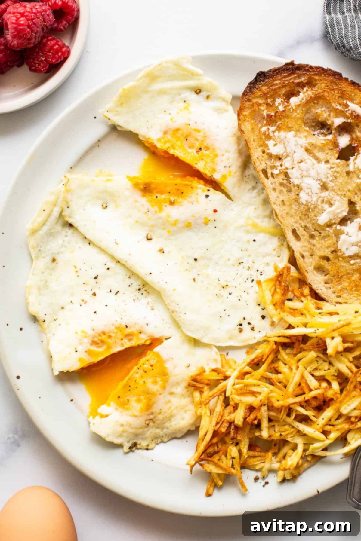 Perfectly cooked over medium eggs served on a plate alongside golden toast, ready for a delicious breakfast.