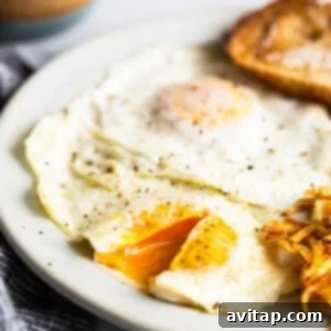 A plate featuring a perfectly fried egg, alongside crispy roasted potatoes and a jar of peanut butter, highlighting a delicious breakfast spread.