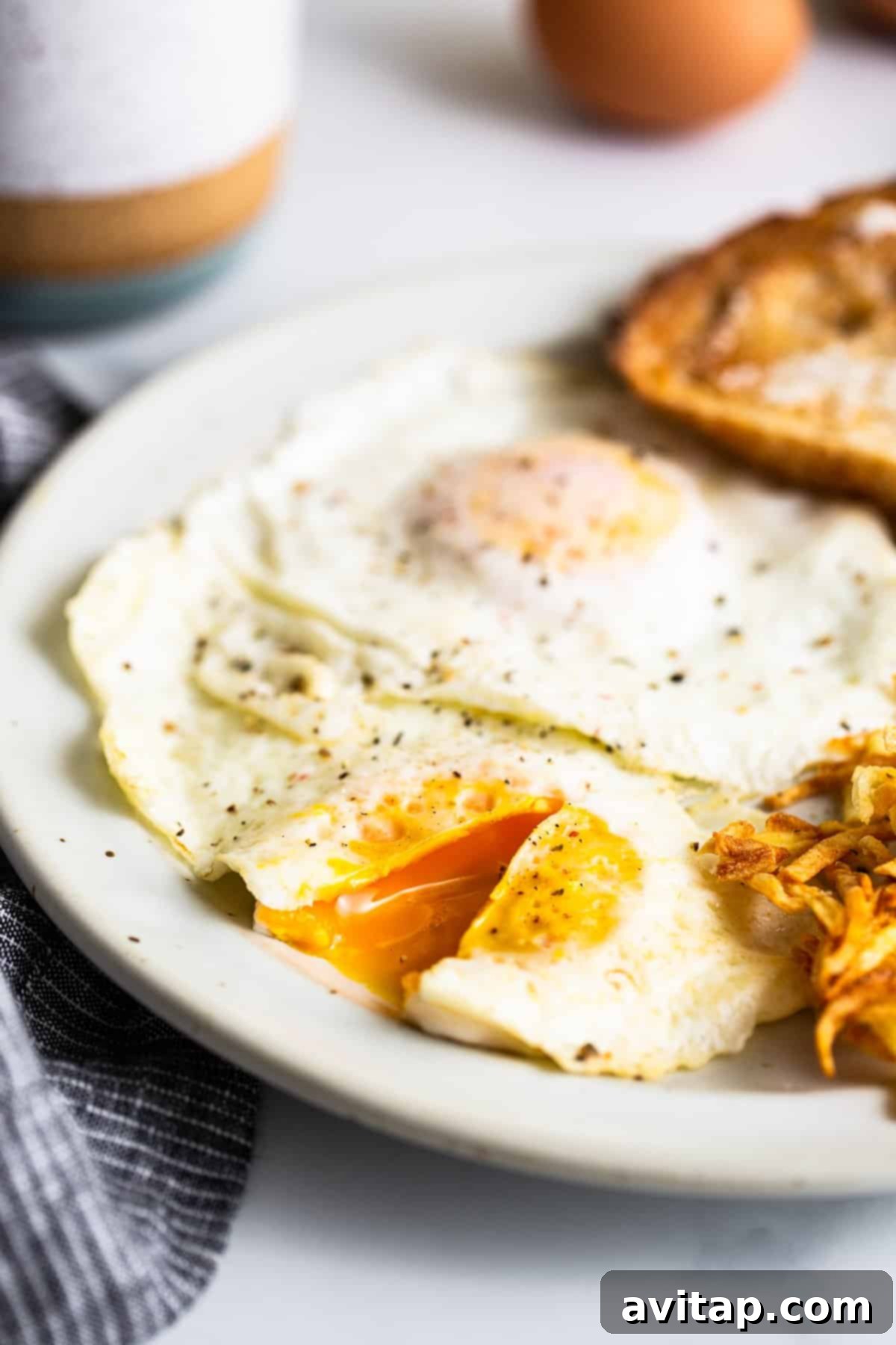 A single perfectly cooked over medium egg, with its bright, jammy yolk, resting on a white plate, ready to be enjoyed.