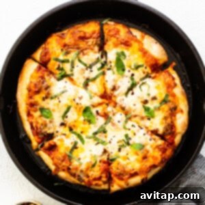 Finished cast iron pizza with a perfectly baked crust and toppings.