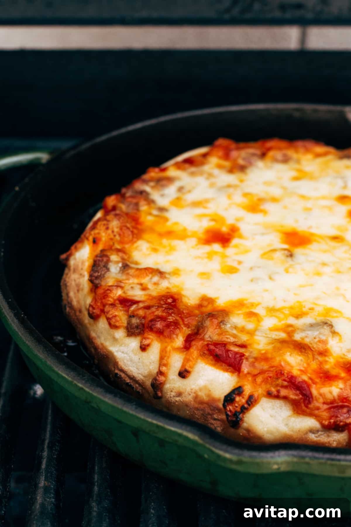 A freshly baked cast iron pizza with melted cheese, glistening sauce, and perfectly browned crust.