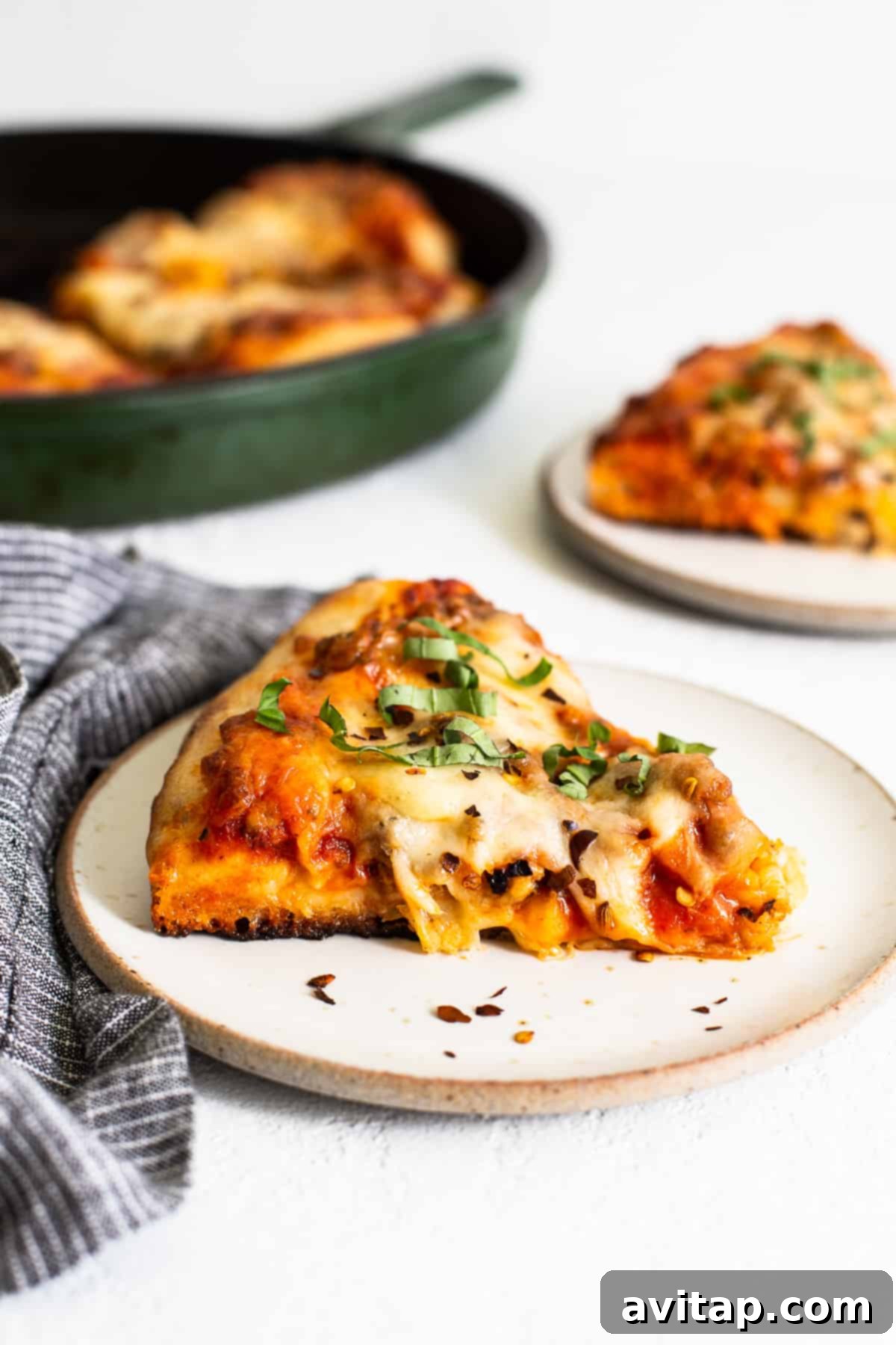 A slice of cast iron pizza perfectly plated and ready to be enjoyed, showcasing its crispy crust and gooey cheese.