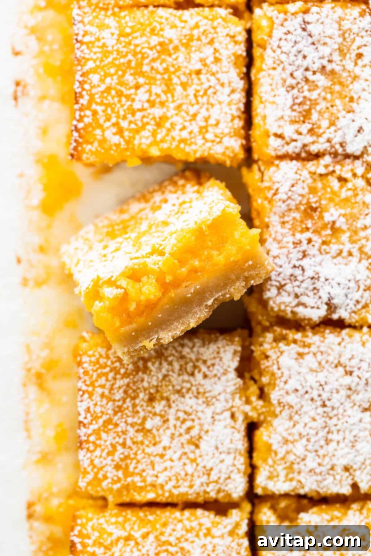 Perfectly sliced lemon bars dusted with powdered sugar, ready to be served.