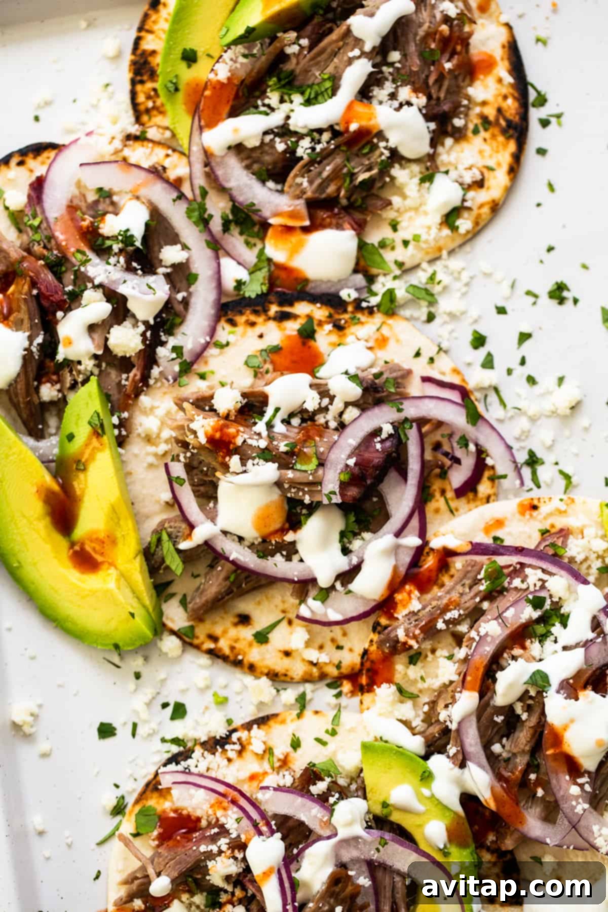 These smoked pulled pork tacos are made with our incredible, fall-off-the-bone smoked pork shoulder and all the best toppings. Delicious shredded pork tacos generously loaded with fresh toppings, ready to be enjoyed.