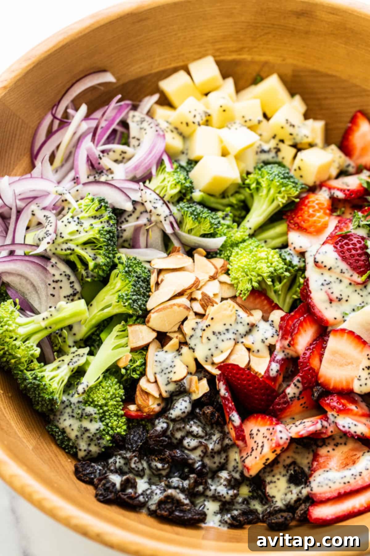 A close-up of a vibrant strawberry broccoli salad, beautifully dressed with poppy seed dressing, ready to be enjoyed.