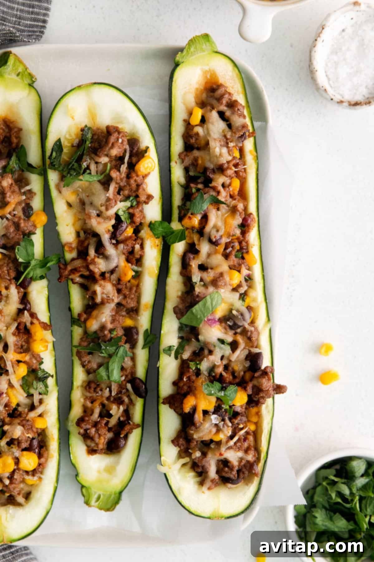 Delicious stuffed zucchini boats served on a plate, garnished with fresh cilantro