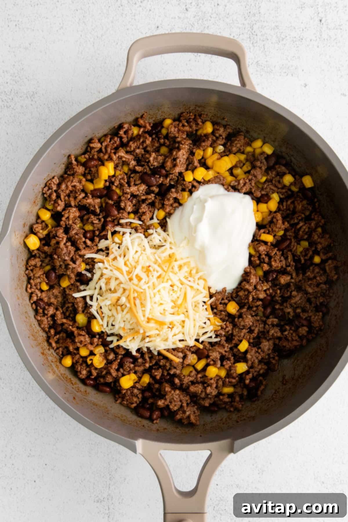 Ground beef taco meat sizzling in a cast-iron skillet, ready for the next steps