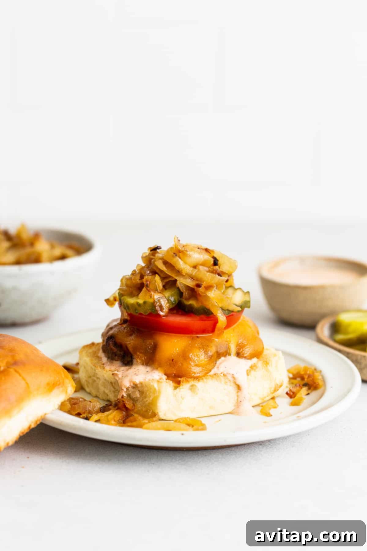 A perfectly cooked homemade burger, glistening with juiciness, served on a toasted bun with fresh toppings like lettuce, tomato, and a generous dollop of burger sauce. It's elegantly presented on a plate, ready to be enjoyed.