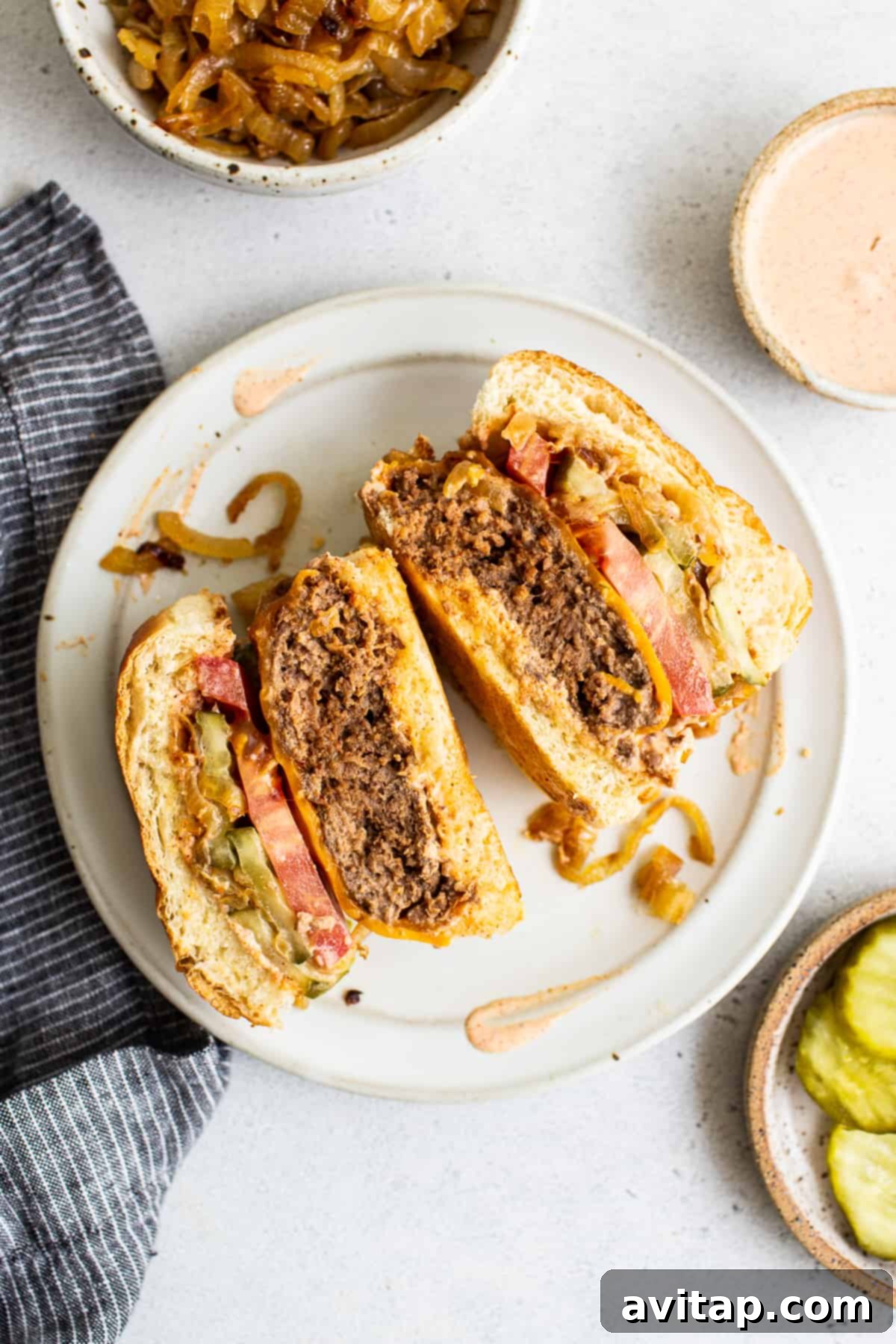 A gourmet homemade burger, skillfully cut in half, elegantly presented on a plate. The cross-section beautifully reveals its juicy interior, perfectly melted cheese, and vibrant fresh toppings, emphasizing its irresistible deliciousness and superior quality.