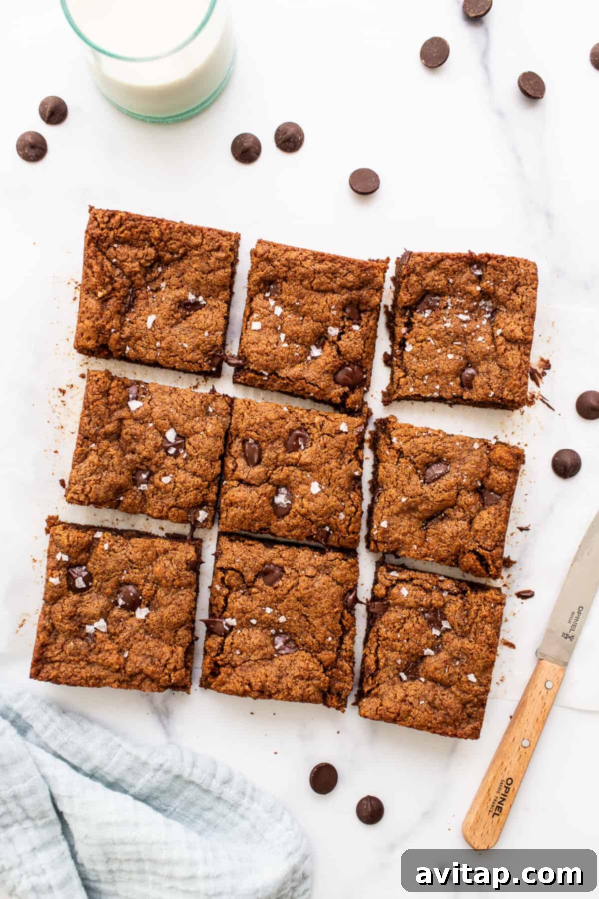 Deliciously sliced flourless almond butter chocolate chip cookie bars arranged on a kitchen countertop, ready to be enjoyed.