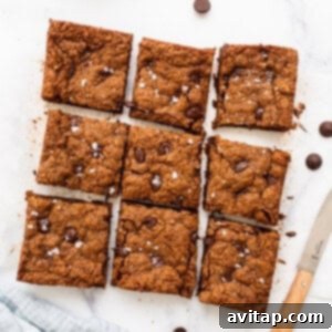 Sliced almond butter chocolate chip cookie bars on a counter.