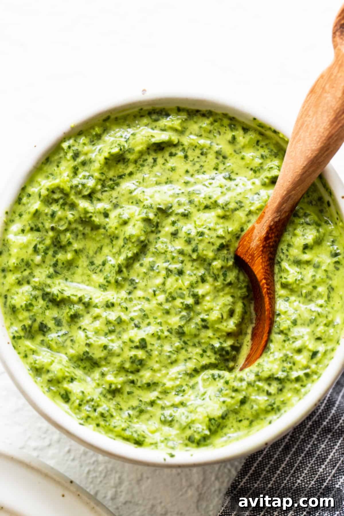 Green sauce in a bowl, showcasing its vibrant color and creamy texture.