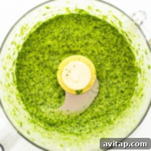 Green sauce in a food processor, mid-blend.