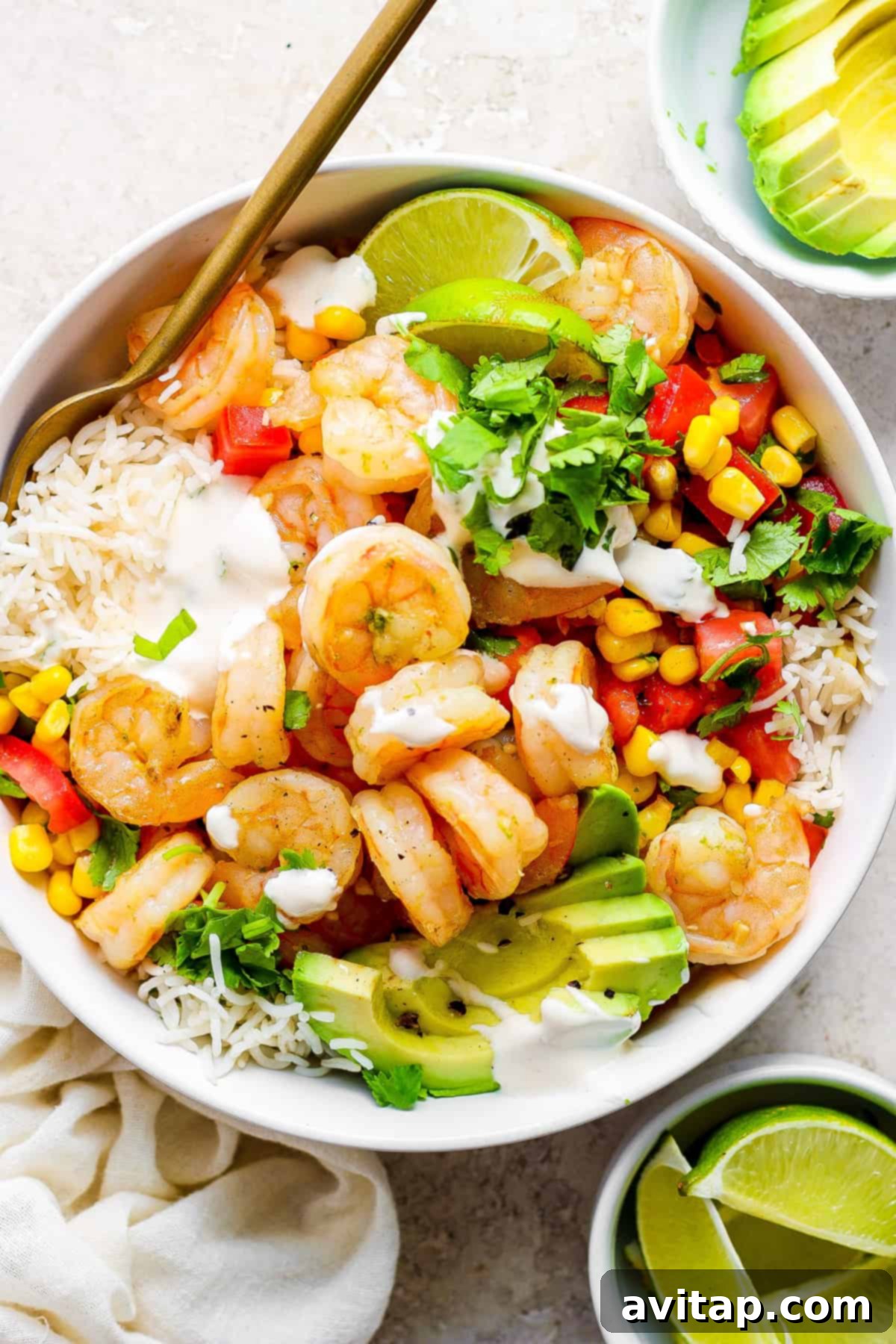 A vibrant cilantro lime shrimp bowl featuring plump, seasoned shrimp, fresh corn, and creamy avocado, served over fluffy rice.