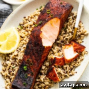 Blackened salmon on a bed of grains, showcasing the rich, dark crust and tender flesh.
