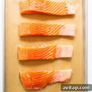 Raw salmon on a lined baking sheet, patted dry.