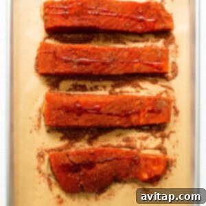 Salmon fillets coated with Cajun seasoning and drizzled with oil.