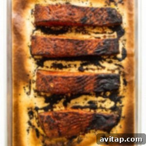 Cooked blackened salmon fillets on a baking sheet, fresh out of the oven.