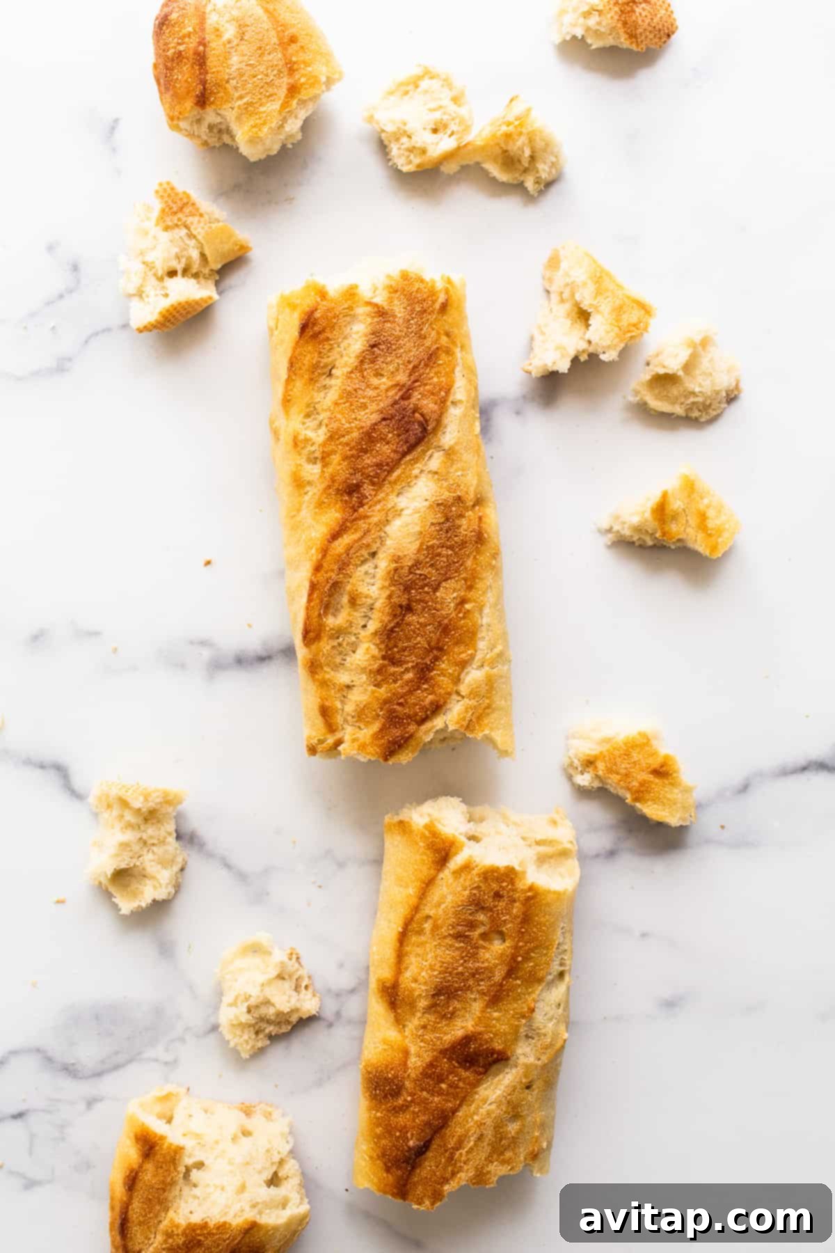 A fresh, crusty French baguette resting on a kitchen countertop, poised to be transformed into delectable homemade croutons.