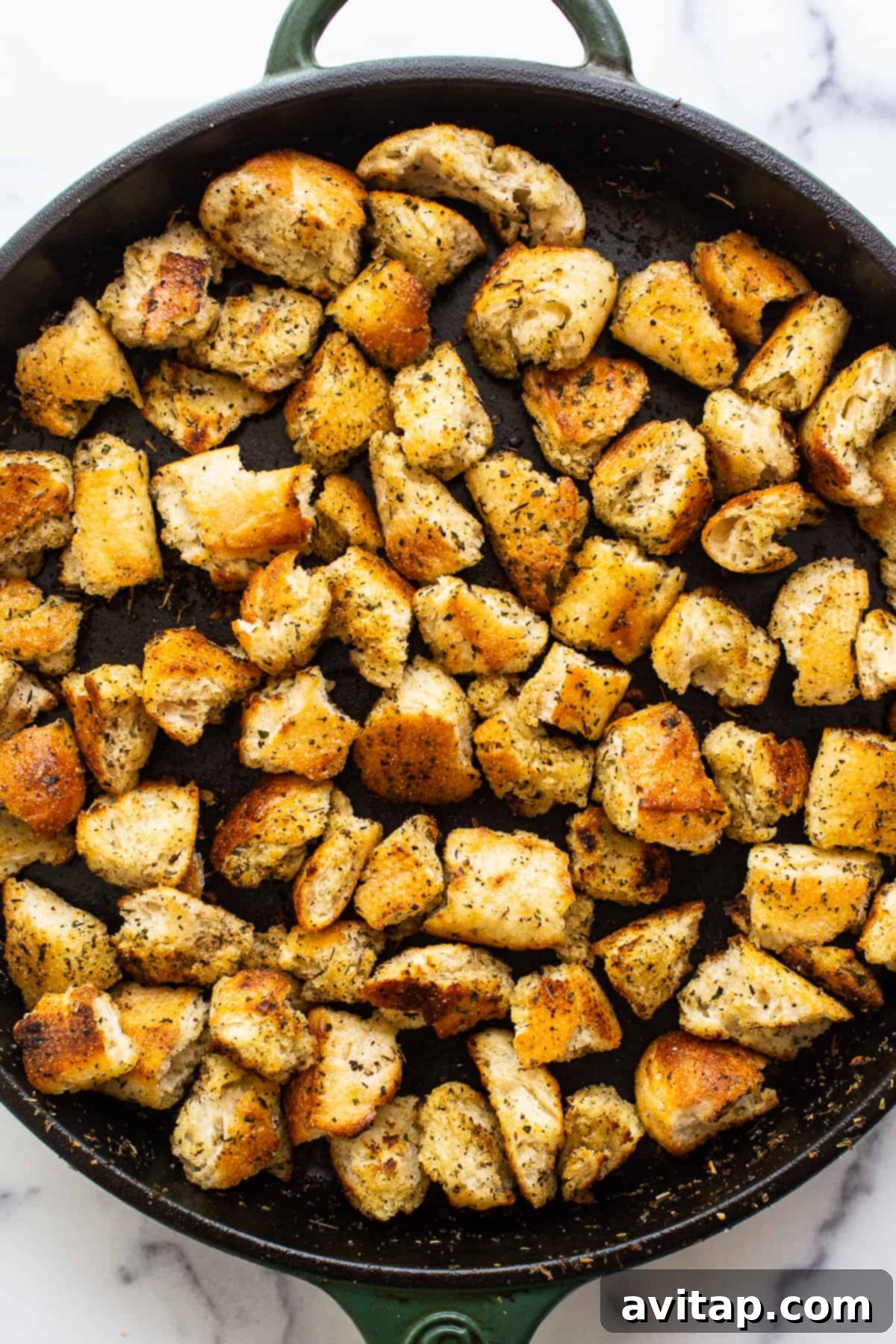 Delicious homemade croutons nestled in a cast iron skillet, beautifully golden brown and perfectly seasoned, ready to be added to your favorite meal or enjoyed as a snack.