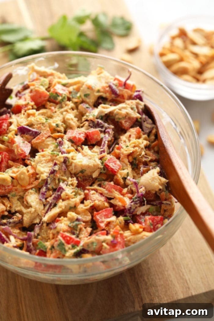 A vibrant bowl of Thai Peanut Chicken Salad, showcasing shredded chicken, colorful vegetables, and a creamy peanut dressing, ready to be enjoyed as a healthy meal.