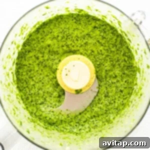 Green sauce blending in a food processor.