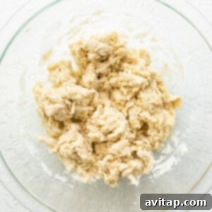 Empanada dough being mixed in a bowl with cold water.