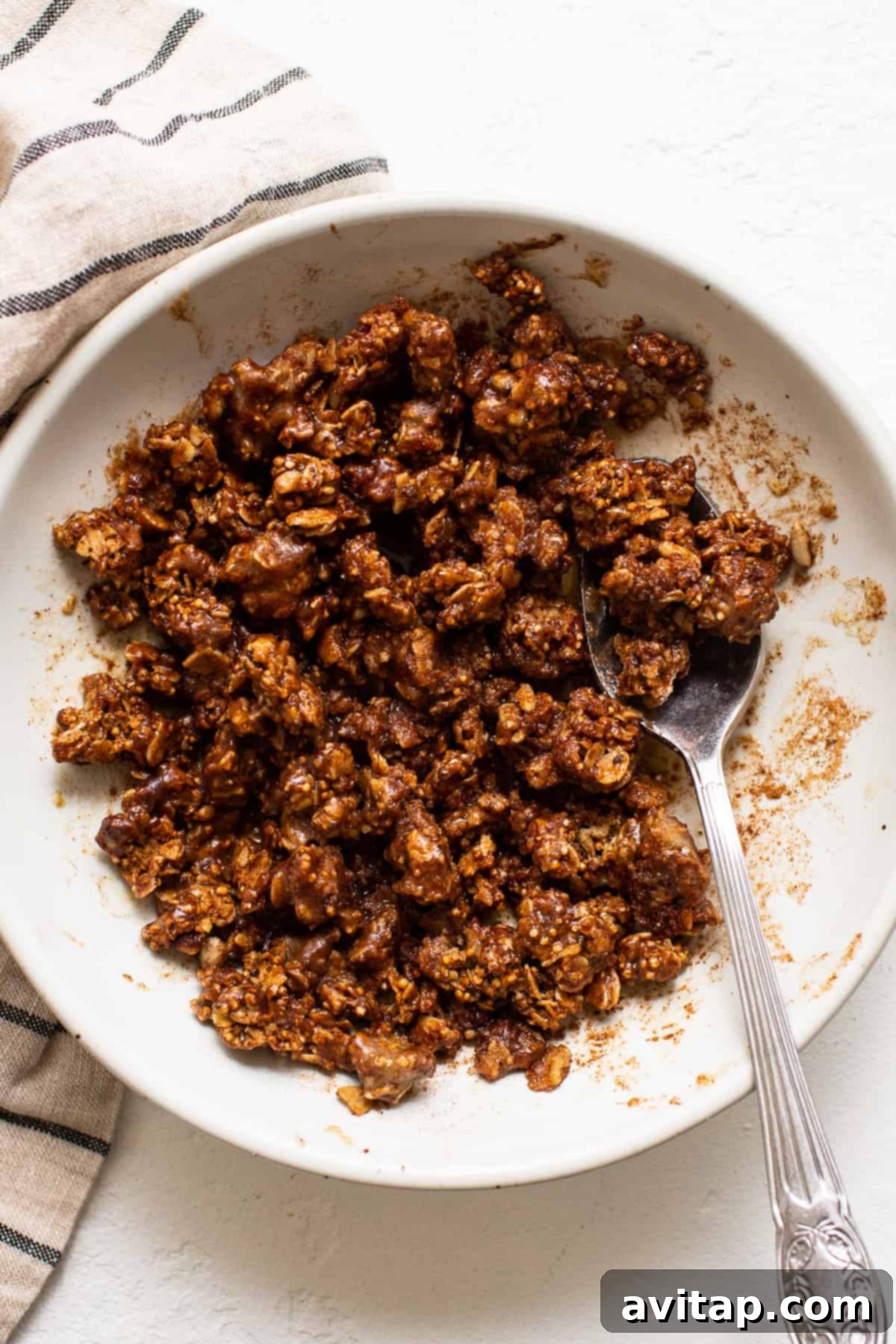 Baked apple streusel filling, a mix of granola, butter, maple syrup, and spices, in a bowl.