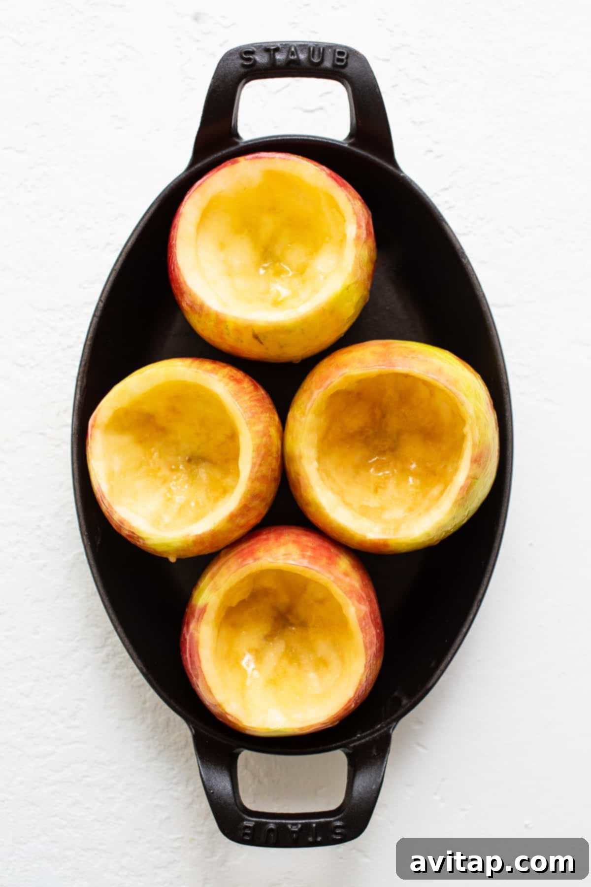 Cored apples placed neatly in a baking dish, ready for their streusel filling.