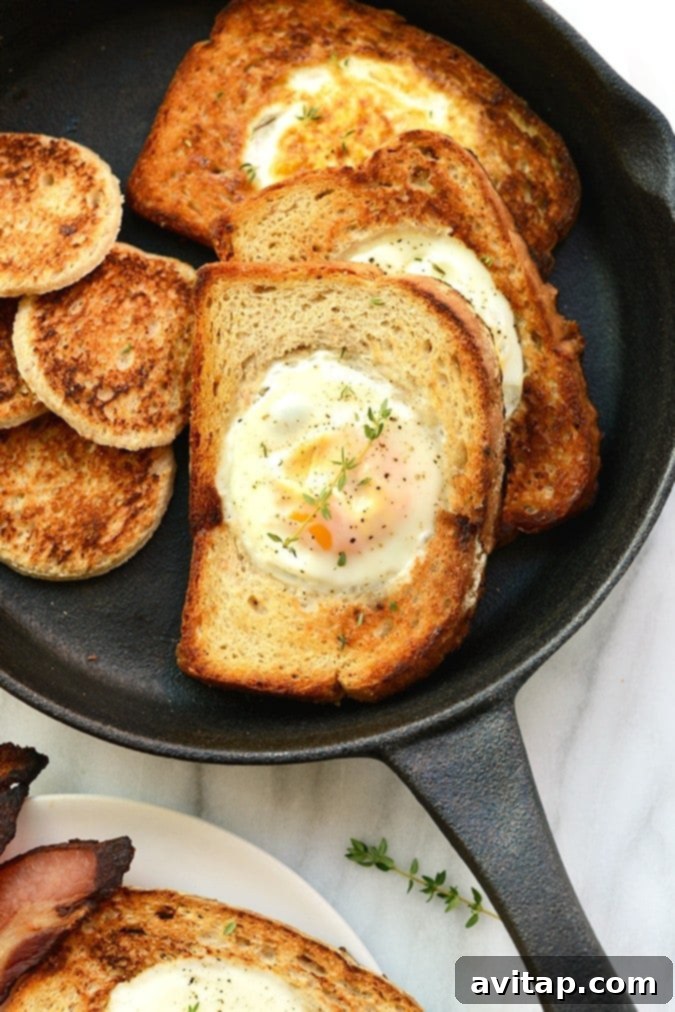Egg in a frame cooking in a cast iron pan, showing the simplicity of this breakfast.