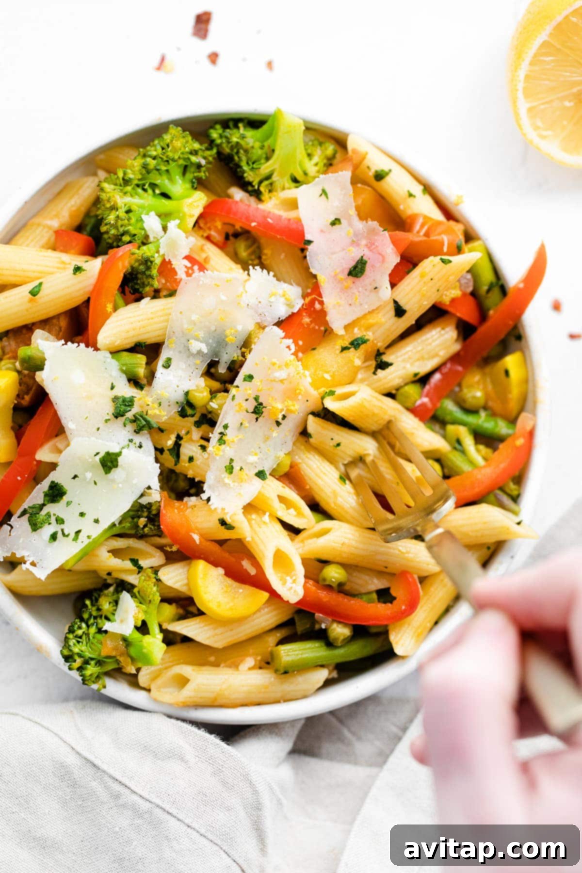 pasta primavera in a bowl topped with parmesan cheese