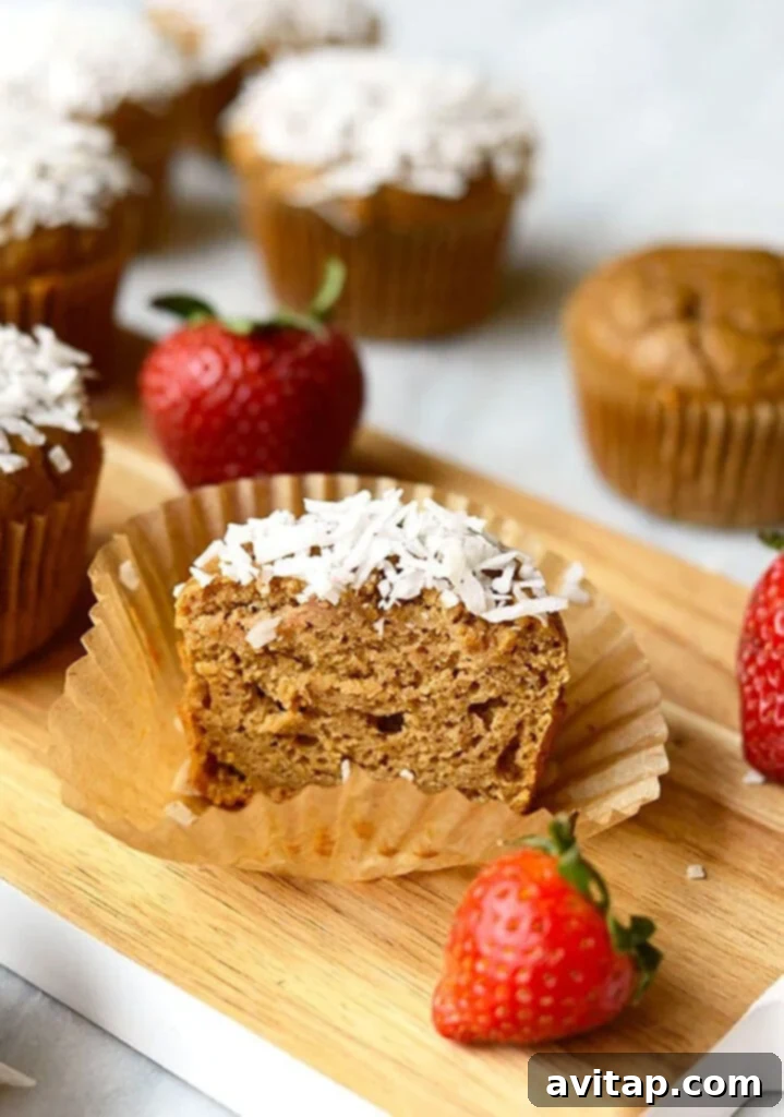Whirlwind Strawberry Banana Muffins 5 A cutting board filled with delightful Coconut Blender Muffins topped with fresh Strawberries, inviting and ready to be served.