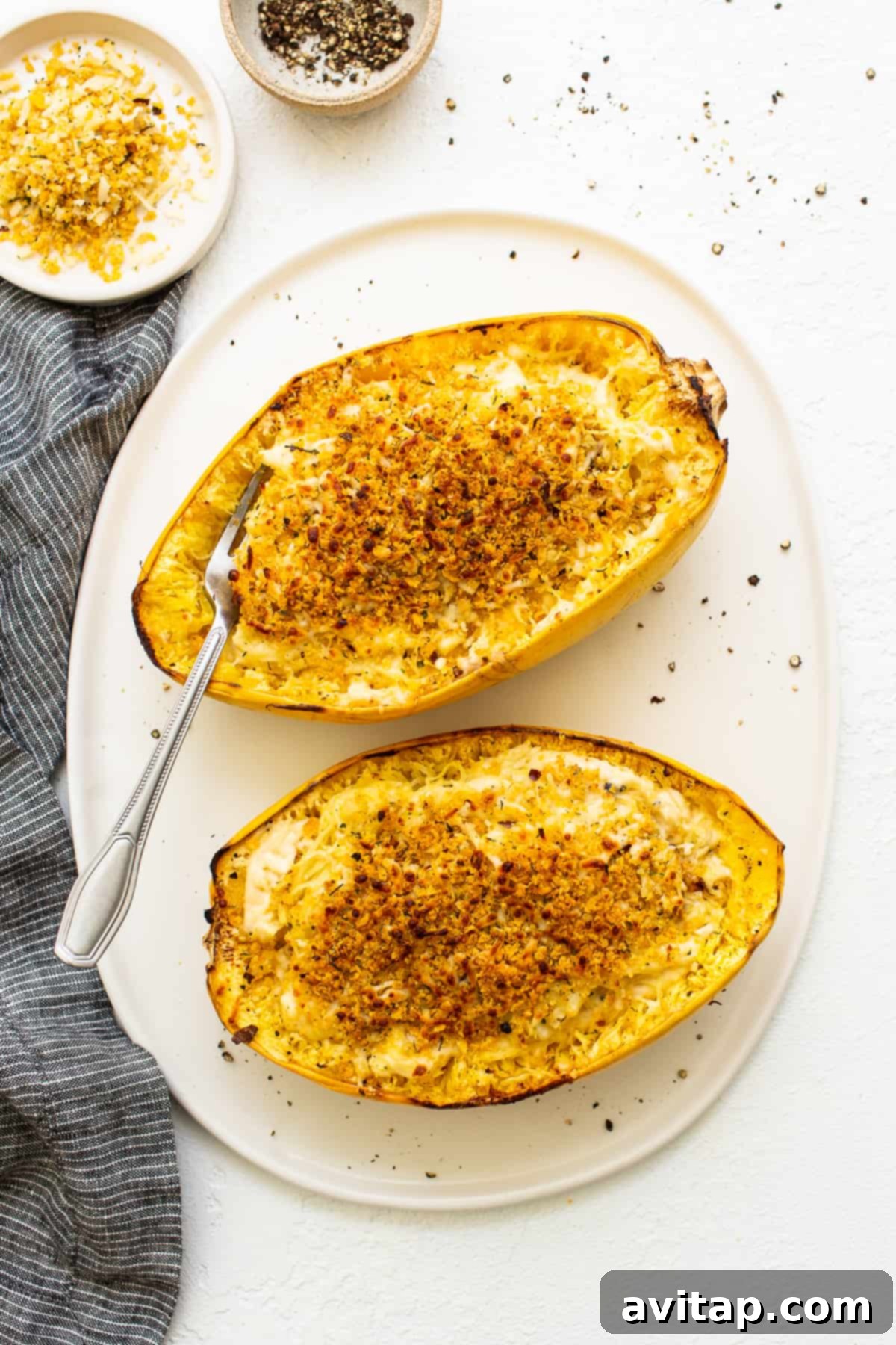 Close-up of baked spaghetti squash mac and cheese with a golden, crispy breadcrumb topping and melted cheese.