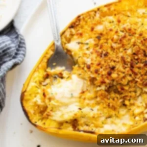 A serving of baked spaghetti squash mac and cheese on a plate, showing the creamy texture and crispy topping.