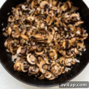 Gourmet Stuffed Pork Chops 7 Mushrooms cooking in a skillet on the stovetop.
