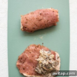 Gourmet Stuffed Pork Chops 8 A hand stuffing a pork chop with the mushroom mixture on a cutting board.