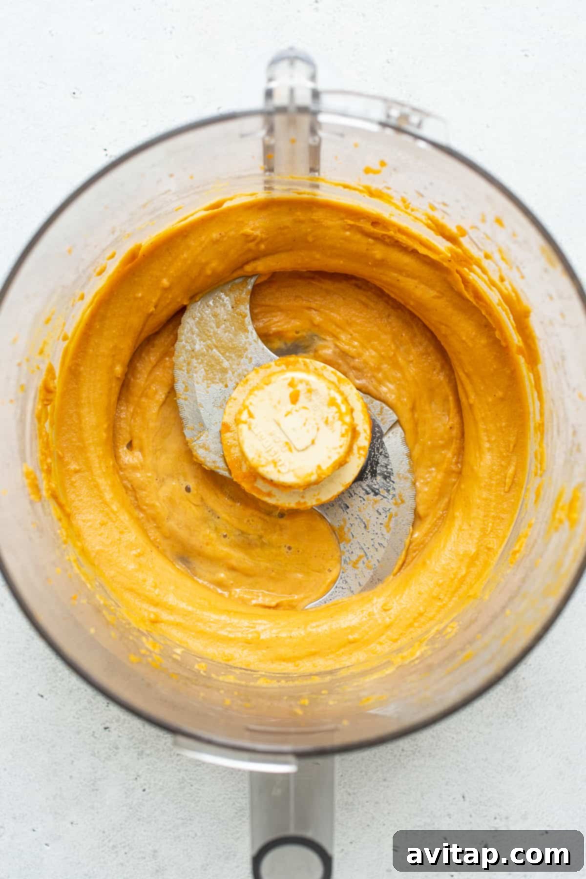 Freshly pureed sweet potato in a food processor, ready for the dog treat recipe.