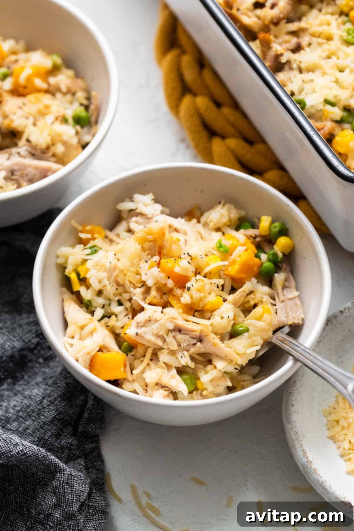 A comforting serving of turkey casserole in a bowl, with a spoon ready to scoop.