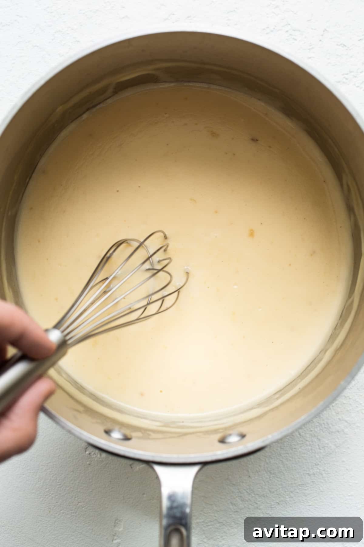 A golden-brown roux simmering in a stock pot, the flavorful base for the creamy casserole sauce.