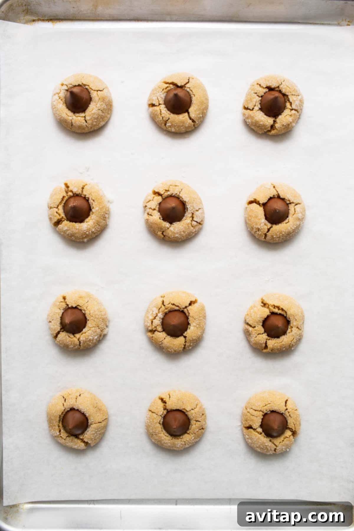 Cooling Down: The Final Touch of Chocolate Freshly baked peanut butter kiss cookies cooling on a wire rack on a baking sheet, with chocolate kisses perfectly melted on top.