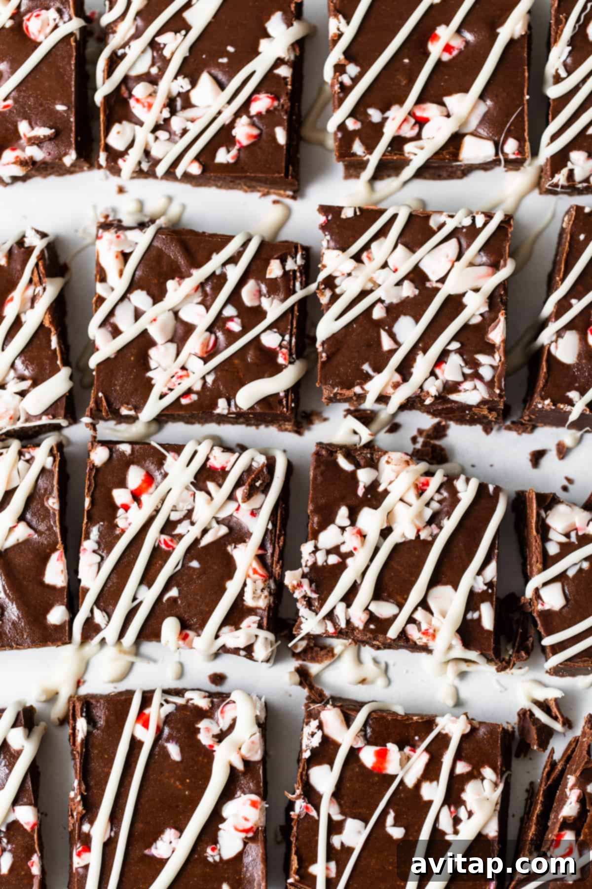 No-Bake Peppermint Fudge 8 Peppermint freezer fudge squares with white chocolate drizzle and crushed peppermint.