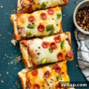 French bread pizza on a cutting board, ready to be sliced.