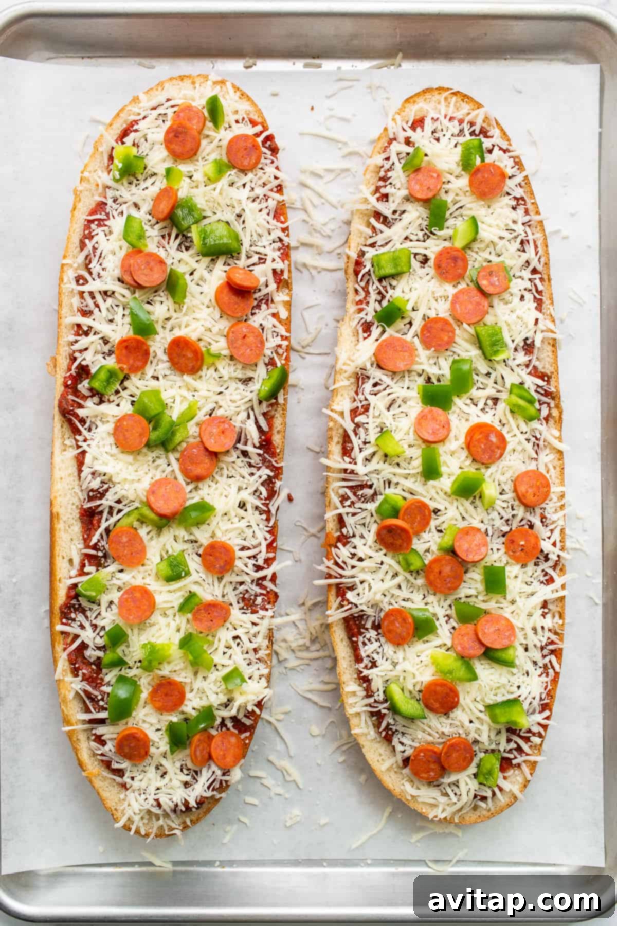 Preparing French Bread Pizza for the Oven French bread pizza assembly on a baking sheet, pre-baking.