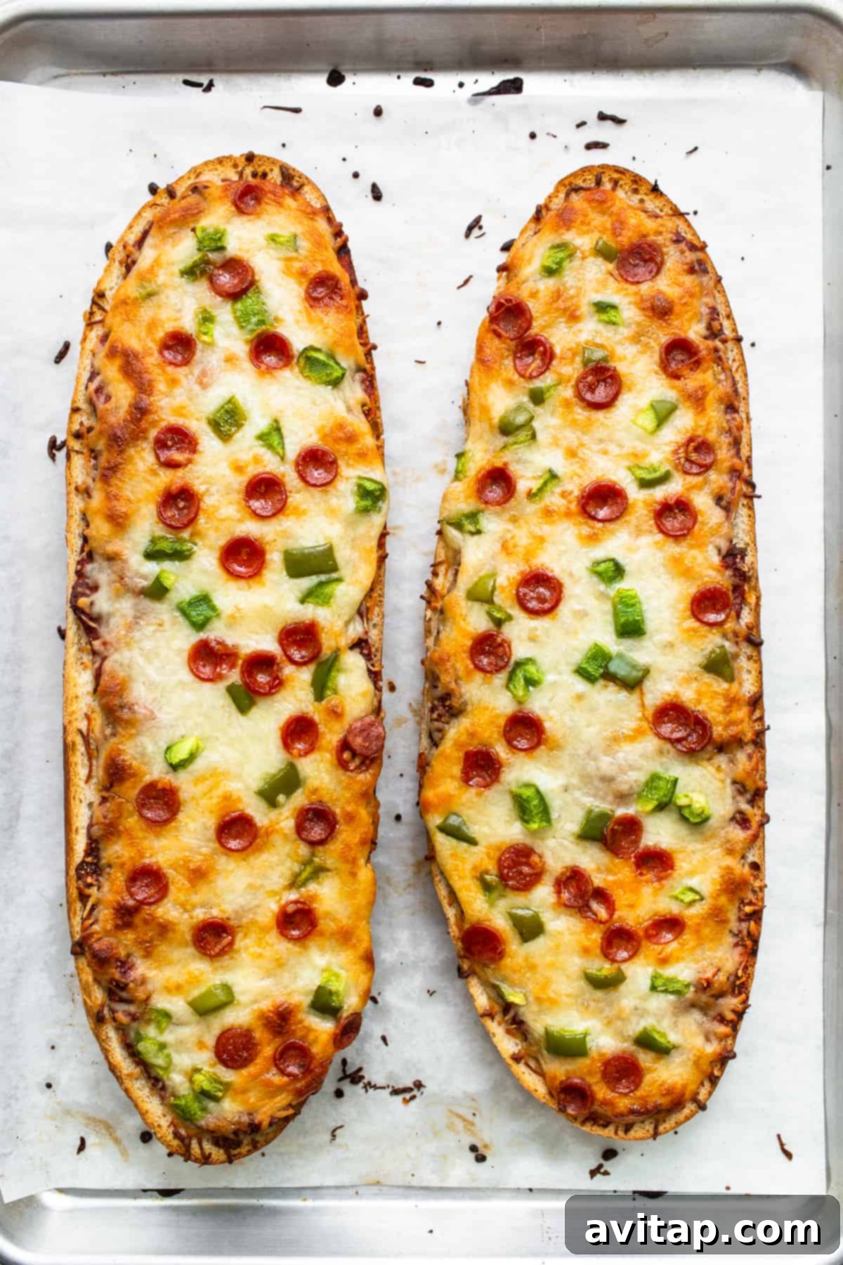 Freshly Baked French Bread Pizza Cooked French bread pizza slices on a baking sheet, golden and bubbly.