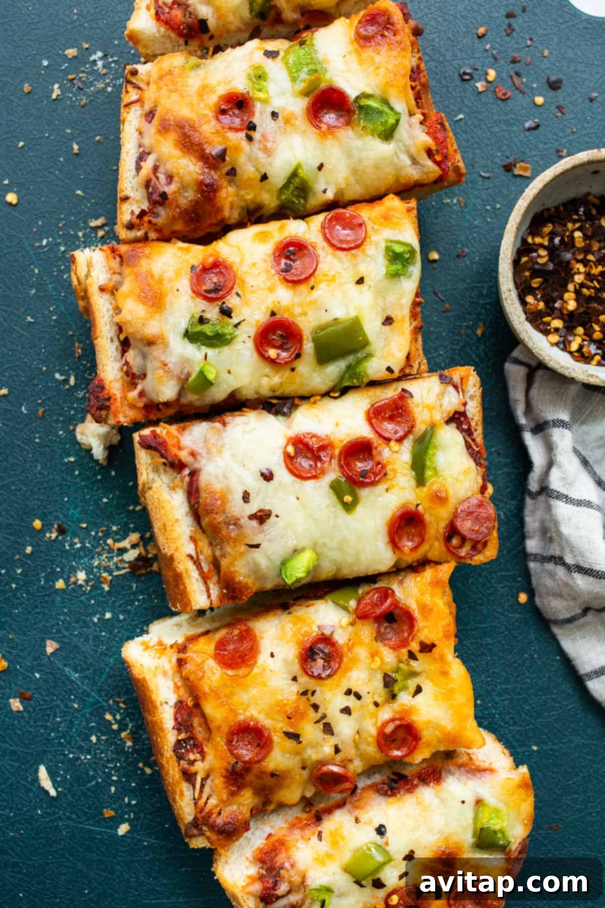 Two perfectly baked slices of homemade French bread pizza, garnished and ready to eat.