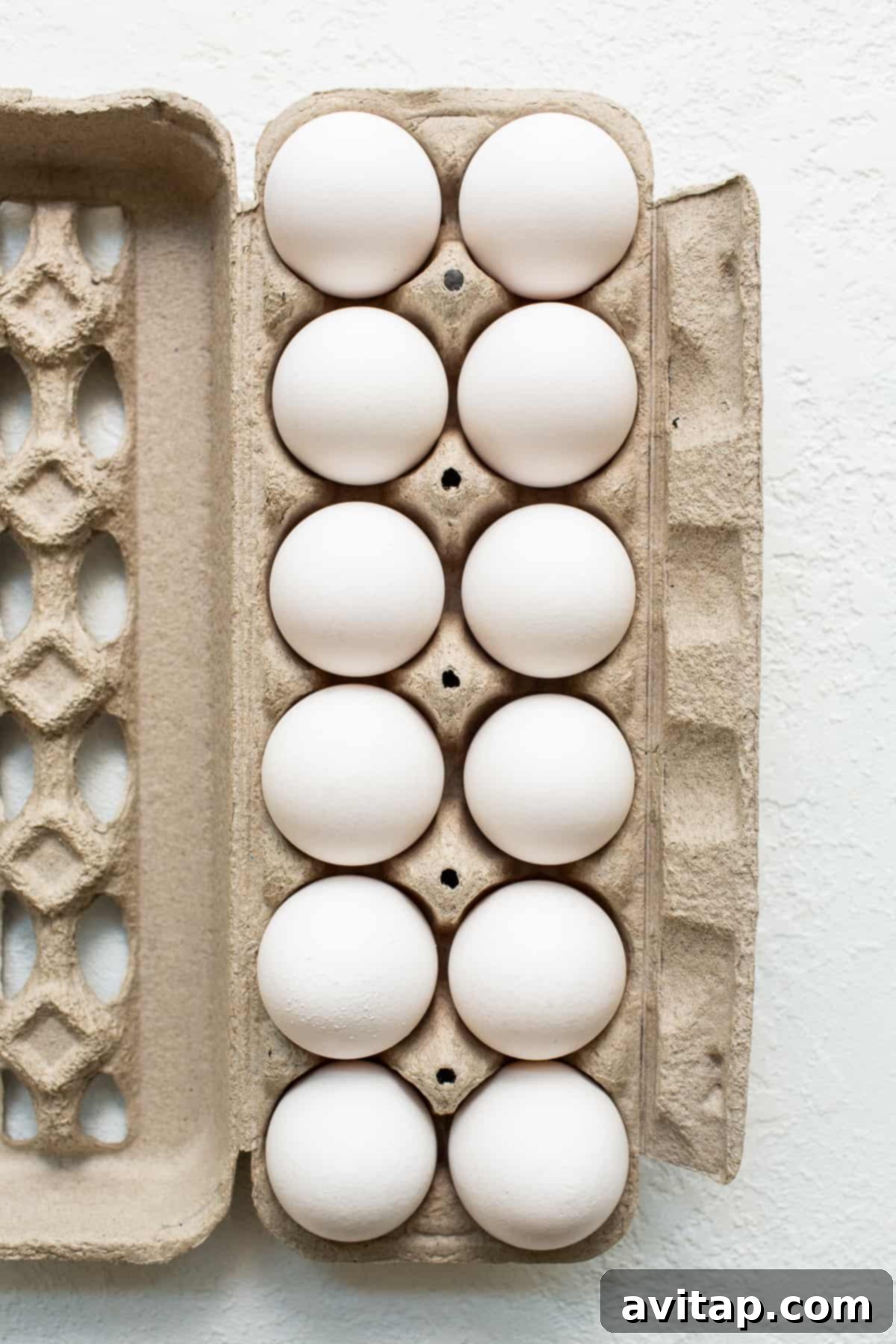 Fresh brown eggs neatly arranged in a cardboard carton, ready for cooking.