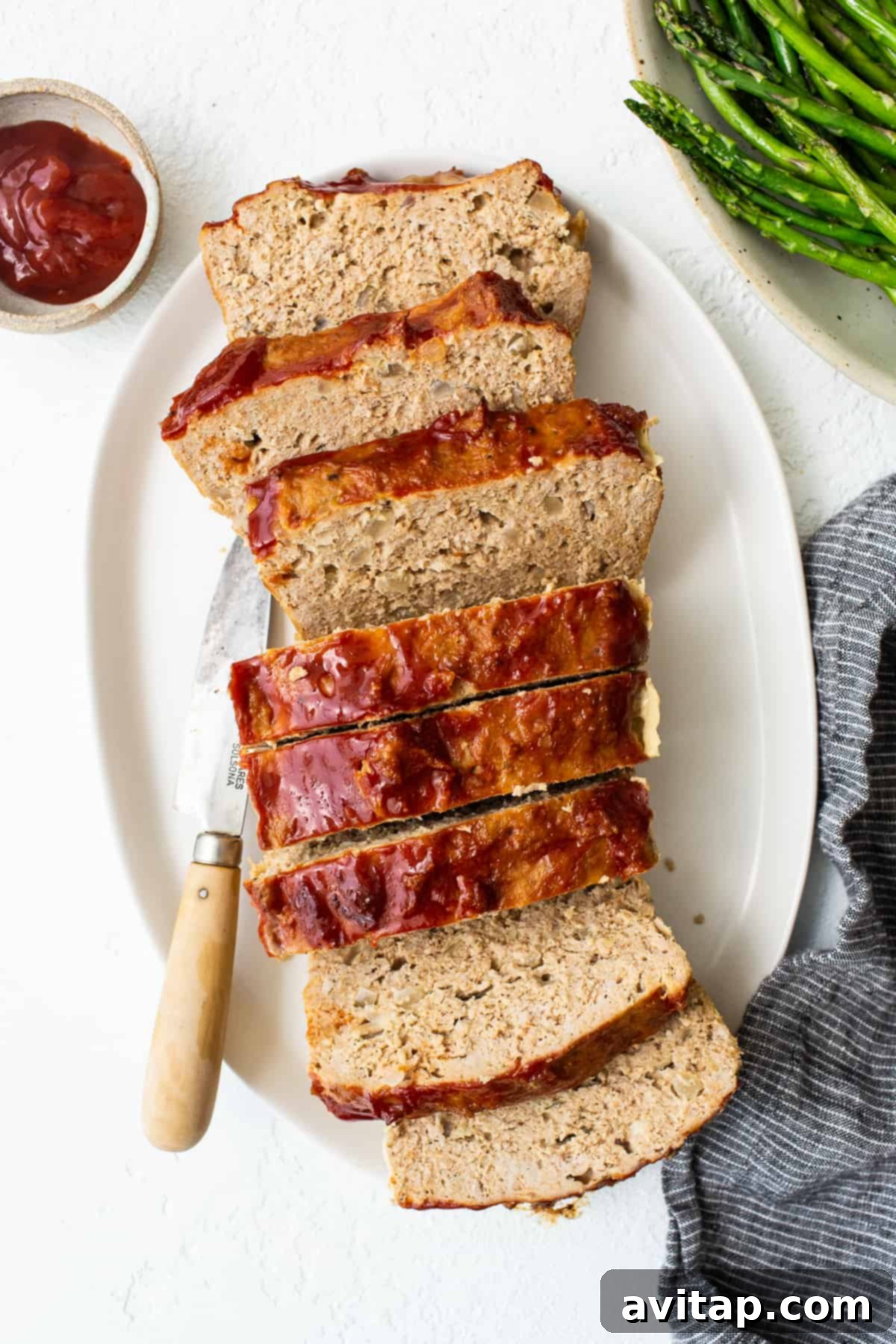 Delicious ground turkey meatloaf, perfectly sliced and ready to serve. Ground turkey meatloaf sliced on a plate, showcasing its moist texture.