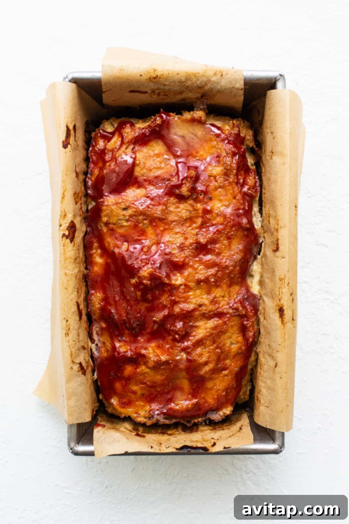 Freshly baked ground turkey meatloaf, golden and inviting. Beautifully baked ground turkey meatloaf, still in the loaf pan, showing its golden-brown top.