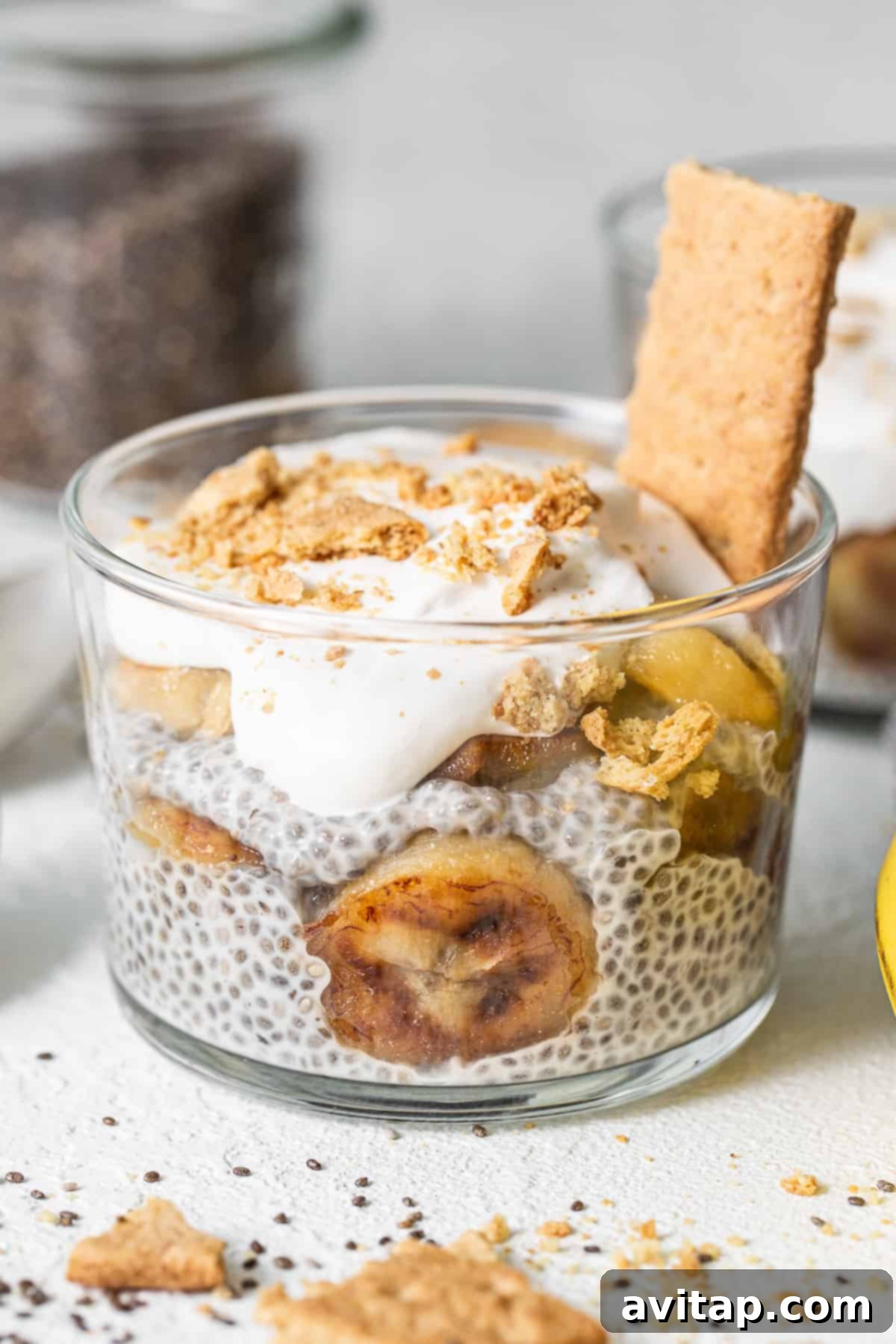 Banana cream pie chia seed pudding in a glass with caramelized banana slices and graham cracker crumbs.